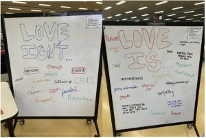 Two white boards labeled "Love Isn't" and "Love Is." Words like "oppressive," "control," "enough" and "jealous" and under Love Isn't, and words like "patient," "unconditional," "empathy" and "eternal" are under Love Is.