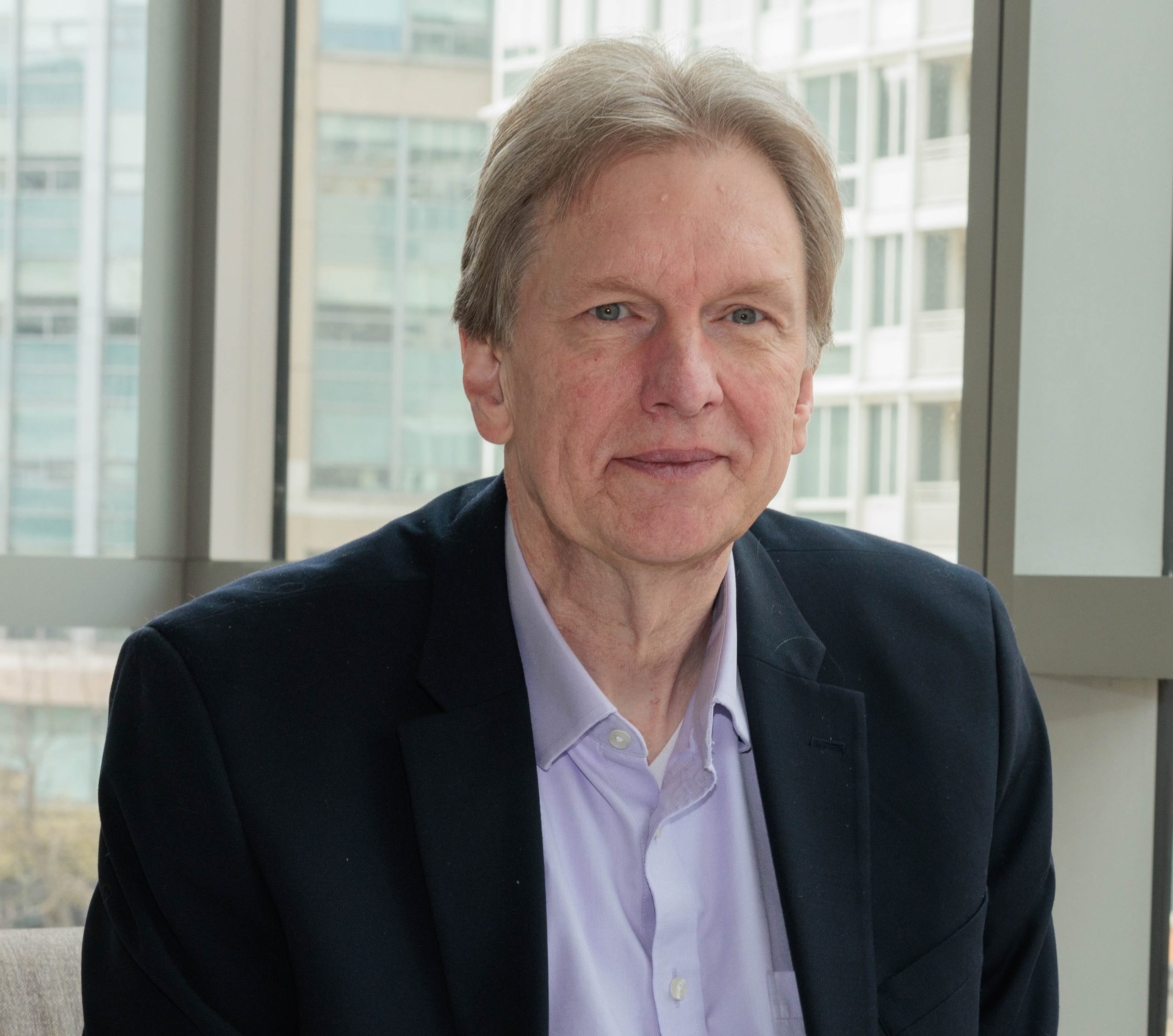 A man in a suit smiles for a photograph.