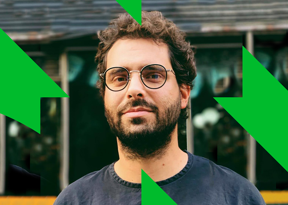 A headshot of a man wearing a T-shirt and glasses.